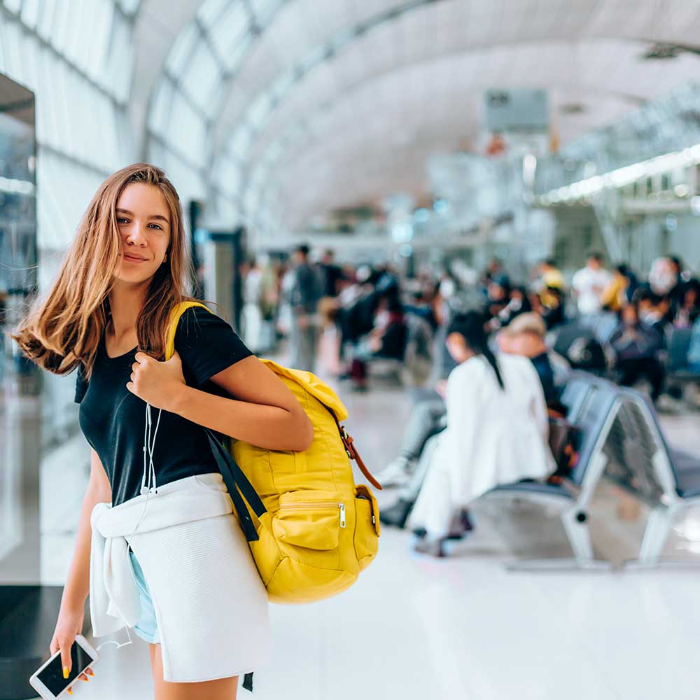 Girl waiting in airport with yellow bag