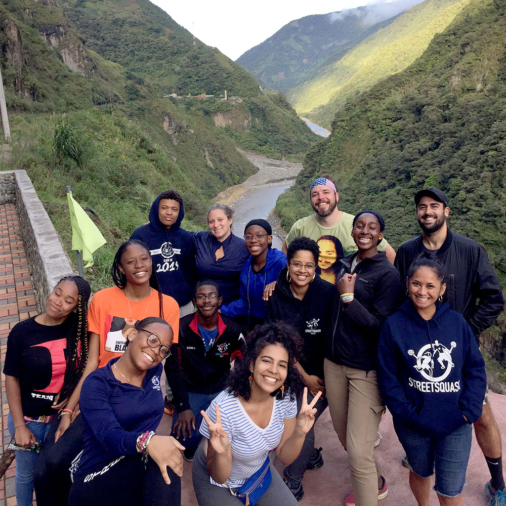 a team of students taking a break from a hike in the crack of a mountain pass